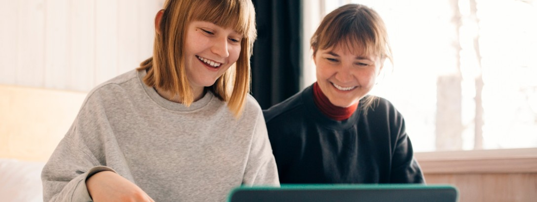 Två kvinnor tittar på en laptop