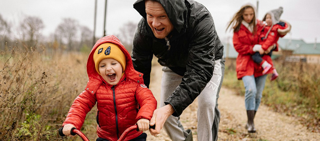 En flicka blåser såpbubblor i solskenet med träd i bakgrunden