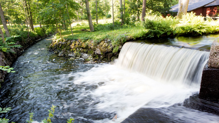 Ett litet vattenfall rinner ner i en å