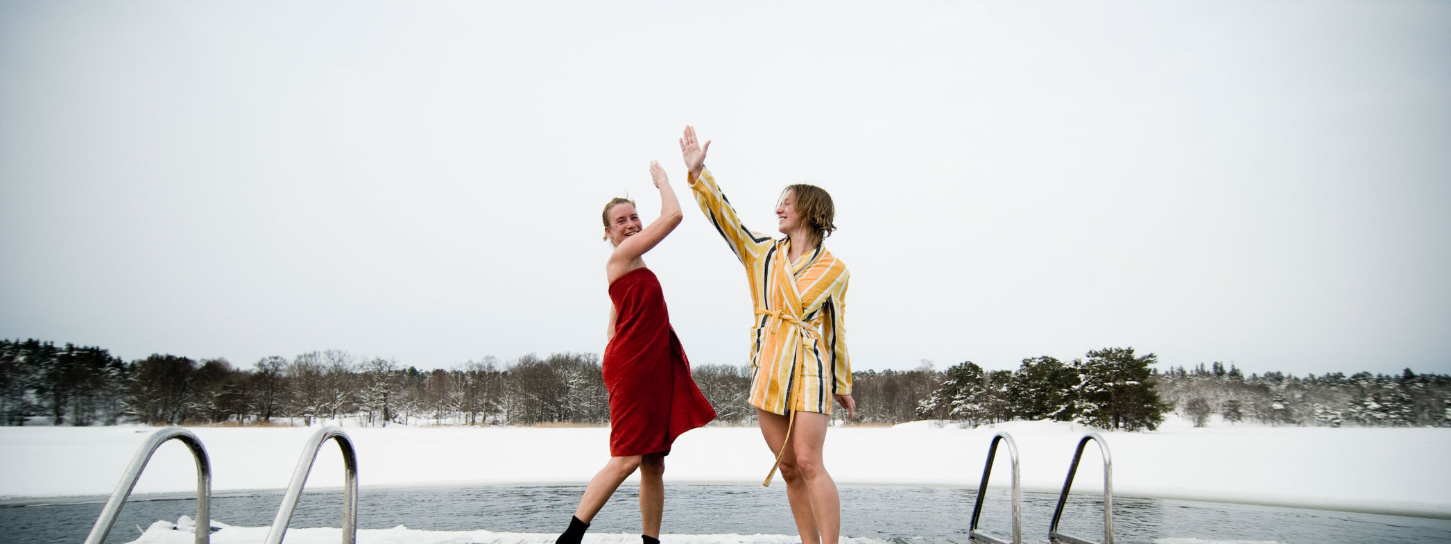 Två kvinnor ger varandra en high5 efter ett isbad