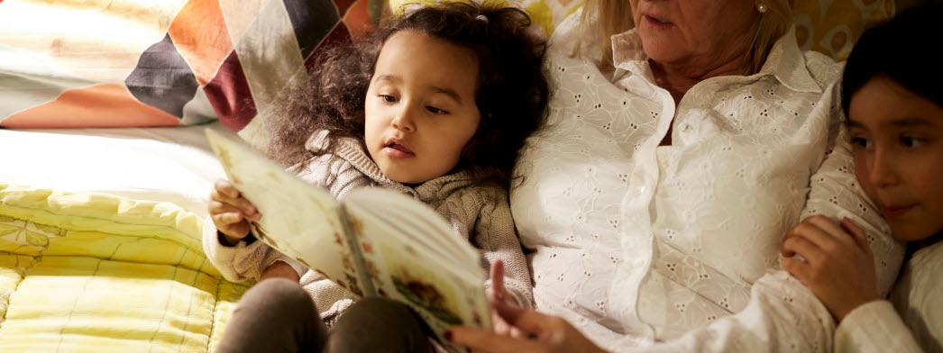 Kvinna läser barnbok för två barn