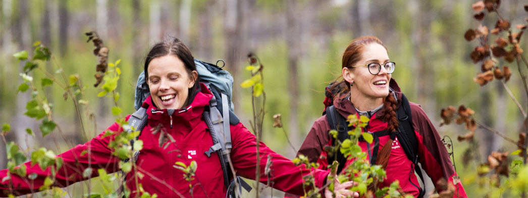 Två kvinnor i röda jackor promenerar i Hälleskogsbrännan